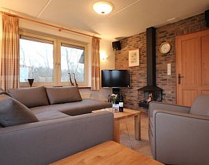 Gemtliches Wohnzimmer in der 6-Personen-Luxusvilla mit Sauna, De Koog, Texel, mit Kamin und bequemen Sitzgelegenheiten.