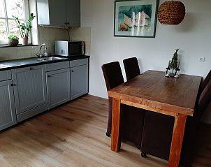 Gezellige keuken in Aan de Maaikeduinen appartement in De Koog, Texel met houten eettafel en moderne apparatuur.