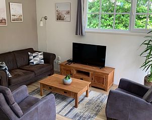 Stijlvolle woonkamer in Aan de Maaikeduinen appartement, De Koog, Texel met comfortabele banken en televisie.