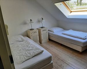 Slaapkamer met twee eenpersoonsbedden in Aan de Maaikeduinen appartement, De Koog, Texel met dakraam.