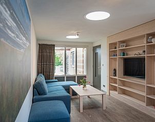 Gezellige woonkamer in Orchismient 24, De Koog, Texel met comfortabele zithoek en uitzicht op de tuin.