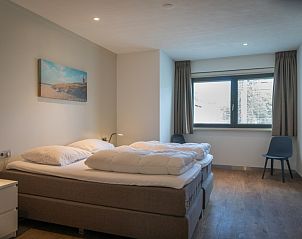 Slaapkamer in Orchismient 24, De Koog, Texel met moderne inrichting en uitzicht op de natuur.