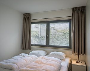 Knusse slaapkamer in Orchismient 24, De Koog, Texel met raam naar buiten en rustige sfeer.