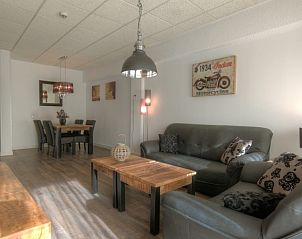 Gezellige woonkamer van Badweg 1A appartement in De Koog, Texel met comfortabele banken en houten meubels.