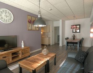 Eetgedeelte in het Badweg 1A appartement, De Koog, Texel, met stijlvolle verlichting en houten eettafel.