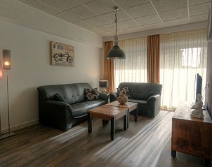 Lichte woonkamer van appartement Badweg 1A, De Koog, Texel met grote ramen en comfortabele zithoek.