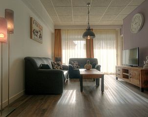 Sfeervolle zithoek in Badweg 1A appartement, De Koog, Texel met moderne inrichting en houten tv-meubel.