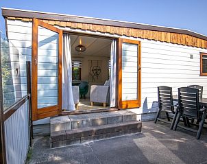 Zonnig terras bij chalet Bosrandweg 409-B in De Koog, Texel, ideaal voor buiten dineren.