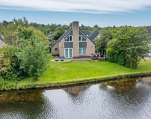 Vakantiehuis Kamperfoelie 51 in De Koog, Texel met uitzicht op groene tuin en waterpartij.