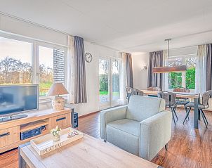 Open leefruimte in Vakantiehuis Kamperfoelie 51, De Koog, Texel met eetgedeelte en tuinzicht.