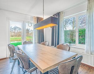 Eetkamer van Vakantiehuis Kamperfoelie 51 in De Koog, Texel met grote tafel en tuinzicht.