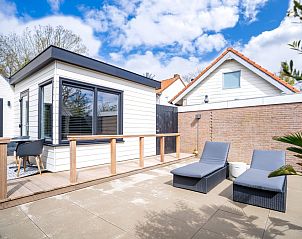 Ruim terras bij Appartement Zee van Tijd in De Koog, Texel met comfortabele ligstoelen en moderne uitstraling.