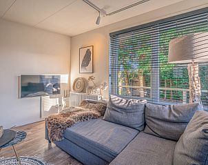 Gezellige woonkamer in Appartement Zee van Tijd, De Koog, Texel met comfortabele bank en natuurlijke lichtinval.
