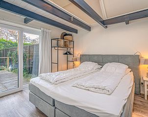 Comfortabele slaapkamer in Appartement Zee van Tijd, De Koog, Texel met toegang tot privterras en serene sfeer.