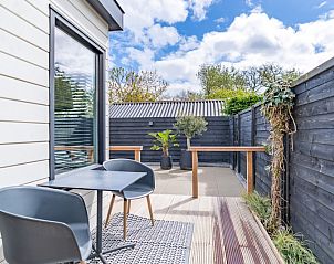 Privterras met zitgelegenheid in Appartement Zee van Tijd, De Koog, Texel voor ontspannen momenten in de buitenlucht.
