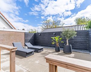 Zonnig terras met ligstoelen in Appartement Zee van Tijd, De Koog, Texel, ideaal voor ontspanning en genieten van de natuur.