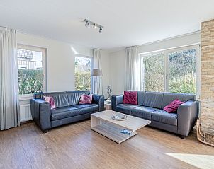 Gemtliches Wohnzimmer des Ferienhauses Kamperfoelie 95 in De Koog, Texel mit bequemen Sofas und Kamin.