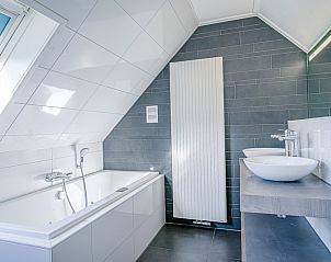 Luxurises Badezimmer im Ferienhaus Kamperfoelie 95, De Koog, Texel mit Badewanne und modernen Waschbecken.