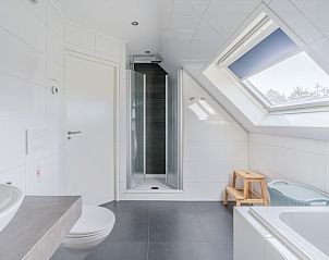 Modernes Badezimmer im Ferienhaus Kamperfoelie 95, De Koog, Texel mit Dusche und Tageslicht durch Dachfenster.