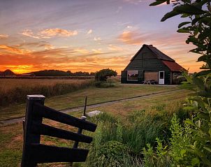 Schapenboet De Boet in De Koog, Texel bij zonsondergang, omgeven door weelderige natuur op de Waddeneilanden.