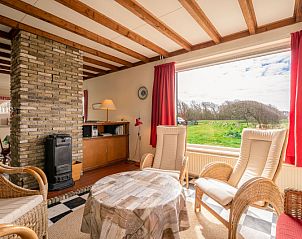 Lichte woonkamer in vakantiehuis Schapenboet De Boet, De Koog, Texel met grote ramen en uitzicht op de natuur.