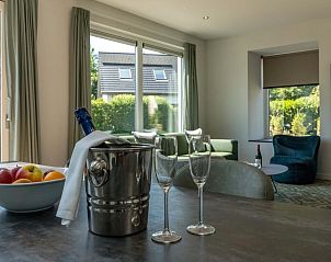 Gezellige woonkamer van vakantiehuis Grutto 16 in De Koog, Texel met uitzicht op groene tuin en comfortabele zithoek.