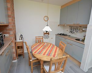 Knusse keukenhoek in Appartement Kerckeland 20, De Koog, Texel met eettafel en moderne voorzieningen.