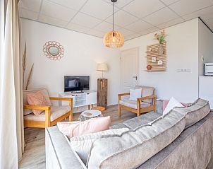 Stijlvolle zithoek in De Duinroos, Texel, met moderne inrichting en natuurlijke lichtinval.