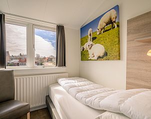 Knusse eenpersoonskamer in De Bosruiter, vakantiehuis op Texel met schapendecoratie.