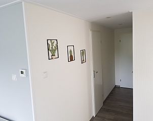 Hal van Chalet Bregkoog 208 in De Koog, Texel, met moderne decoraties en toegang tot de slaapkamers.