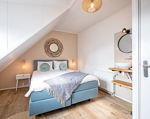 Gezellige hoek van de slaapkamer in De Strandleeuwerik, vakantiehuis in De Koog, Texel met zacht beddengoed en natuurlijke lichtinval.