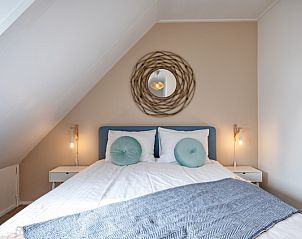 Knusse slaapkamer in De Strandleeuwerik, Texel, met een stijlvol interieur en comfortabele voorzieningen voor een ontspannen verblijf.