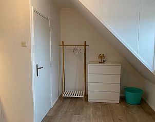 Praktische opbergruimte in De Strandleeuwerik, vakantiehuis in De Koog, Texel met moderne kledingkast en minimalistisch design.