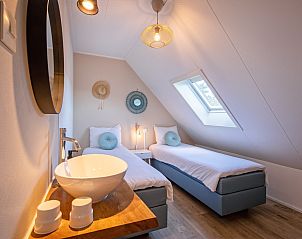 Stijlvolle slaapkamer in De Strandleeuwerik, vakantiehuis op Texel, met moderne details en veel natuurlijk licht.