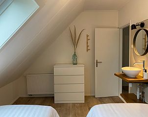Frisse slaapkamer in De Strandleeuwerik, De Koog, Texel met comfortabele bedden en een moderne wastafel voor extra gemak.