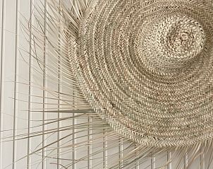 Detail van het interieur in De Strandleeuwerik, Texel, met een rustiek vlechtwerk accent dat de ruimte charme geeft.