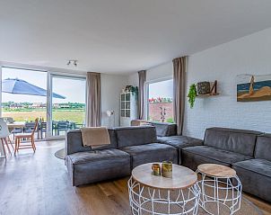 Gezellige woonkamer van Huisje in De Koog, Texel, met uitzicht op het landschap van de Waddeneilanden.