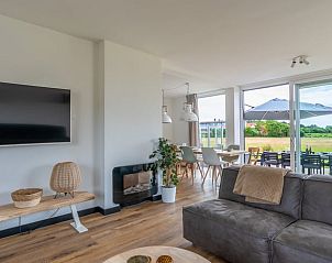 Moderne woonkamer in Huisje in De Koog, Texel, met comfortabele bank en uitzicht op de Waddeneilanden.