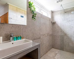 Ruime badkamer in Huisje in De Koog, Texel, met inloopdouche en moderne wastafel.