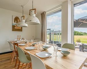 Eetkamer met uitzicht op de natuur in Huisje in De Koog, Texel, ideaal voor gezellige diners.