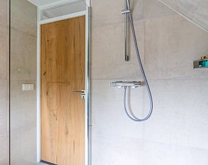 Stijlvolle douche in Huisje in De Koog, Texel, met houten deur en moderne afwerking.