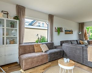 Gezellige zithoek in Huisje in De Koog, Texel, met uitzicht op de tuin en de Waddeneilanden.