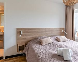 Slaapkamer met en-suite badkamer in Huisje in De Koog, Texel, met moderne inrichting.