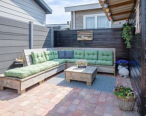 Stijlvolle loungehoek met groene kussens bij Chalet Bregkoog 88 in De Koog, Texel, op Chaletpark Bregkoog.