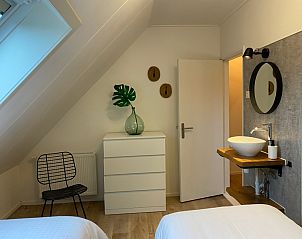 Modernes Schlafzimmer mit Waschbecken und dekorativen Elementen in De Boomleeuwerik, Texel.