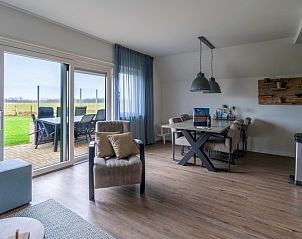 Lichte woonkamer met uitzicht op terras in vakantiehuis Nieuwlanderweg 77, De Koog Texel.