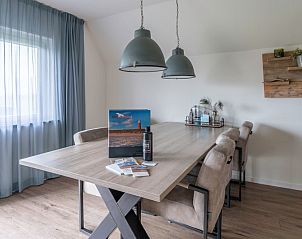 Stijlvolle eetruimte in vakantiehuis Nieuwlanderweg 77, De Koog Texel met houten tafel.