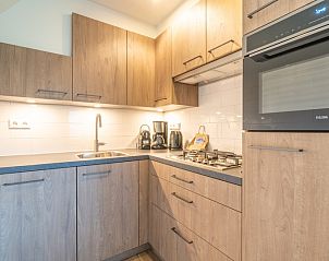 Moderne keuken in vakantiehuis Nieuwlanderweg 77, De Koog Texel met houten kasten.
