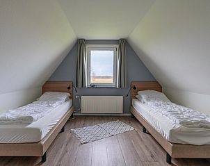 Heldere slaapkamer met uitzicht op natuur in vakantiehuis Nieuwlanderweg 77, De Koog Texel.