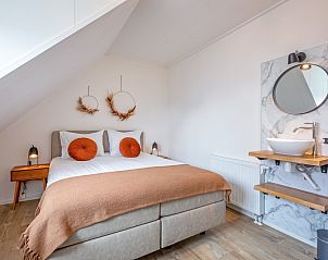 Gezellige slaapkamer in Windlust vakantiehuis De Koog Texel met moderne wastafel.